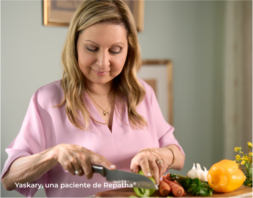 Mujer vestida de rosa cortando frutas y verduras.
